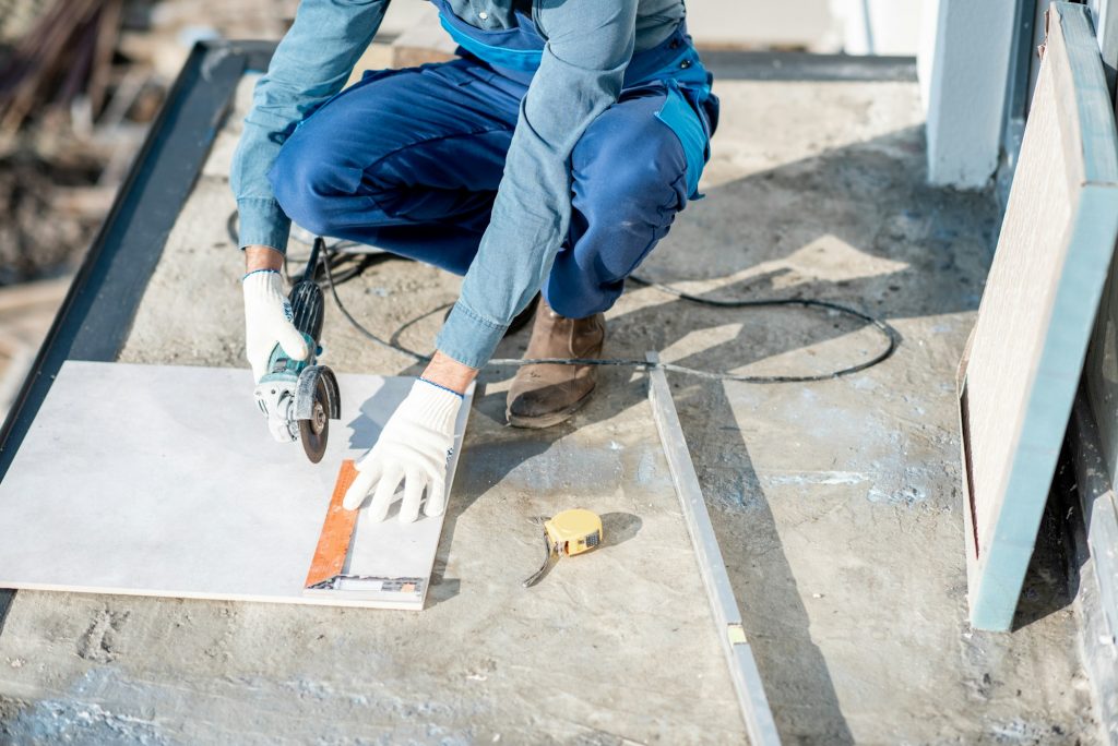 Workman laying tiles on the balcony